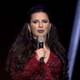 Ruja Ignatova standing with a microphone to her lips.